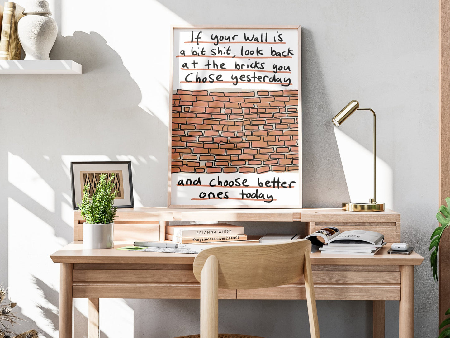 Home office with wooden desk, chair, and framed quote on wall